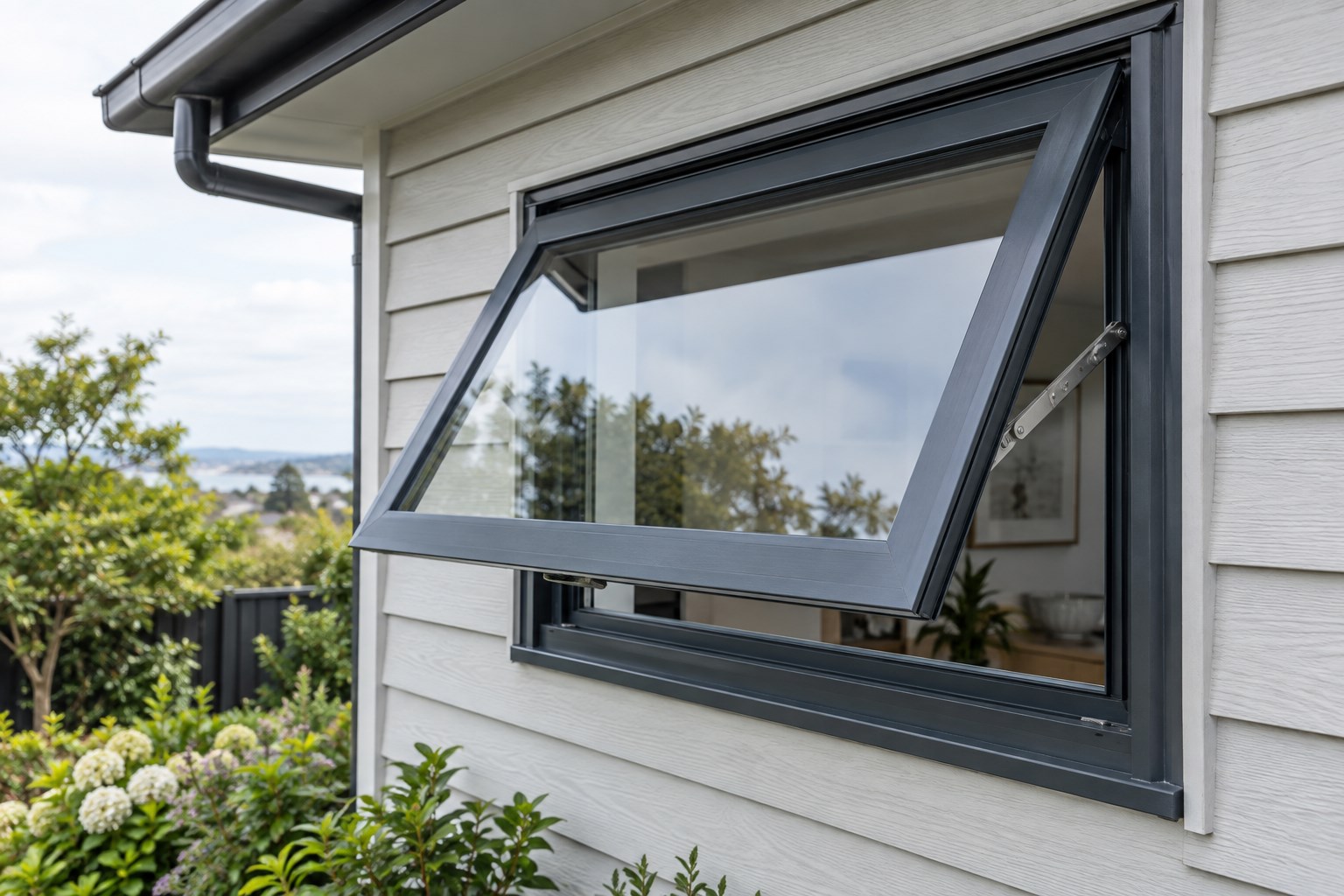 Charcoal aluminium awning window open on a weatherboard home